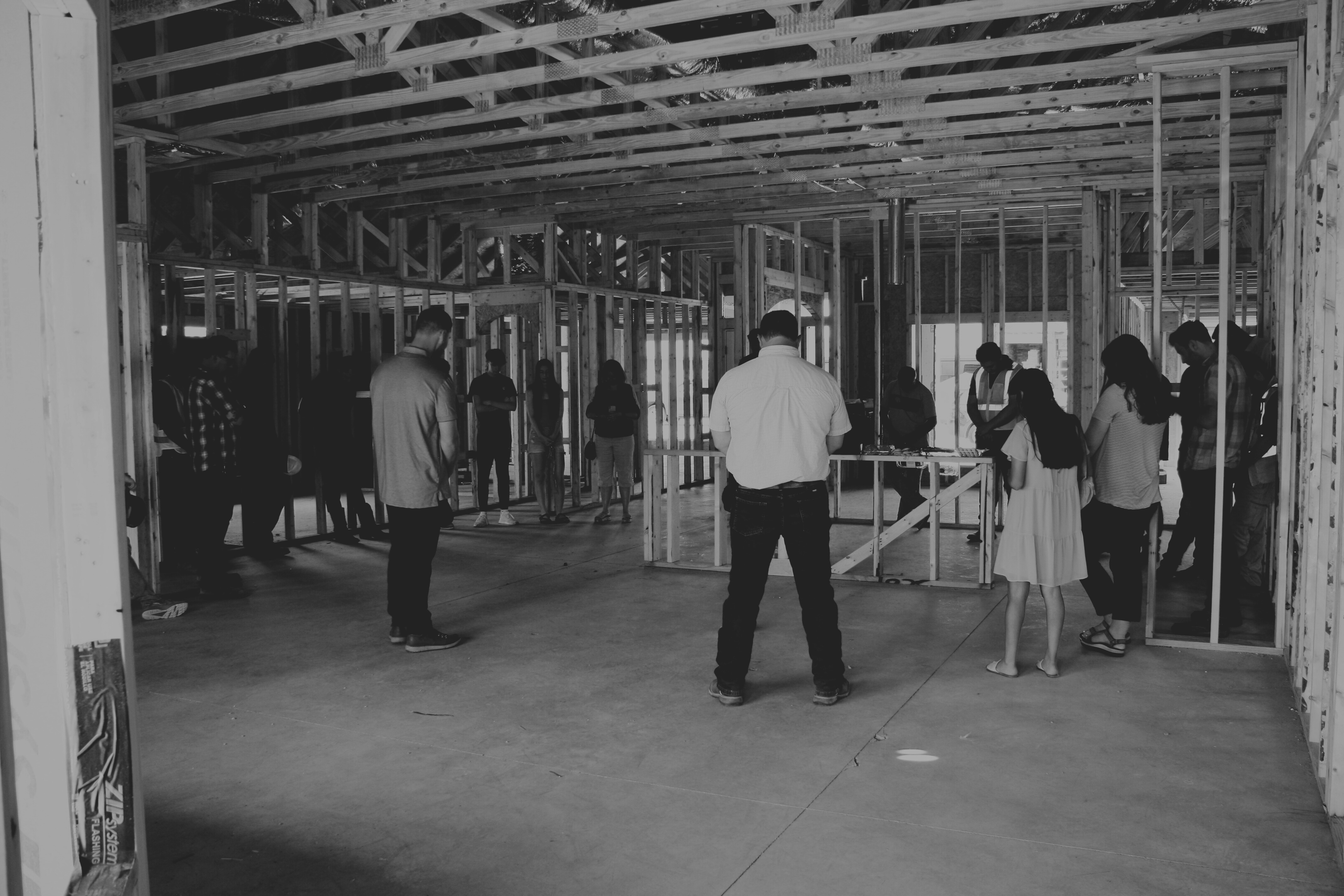 Friends and family gathered inside the framed structure praying over the new home